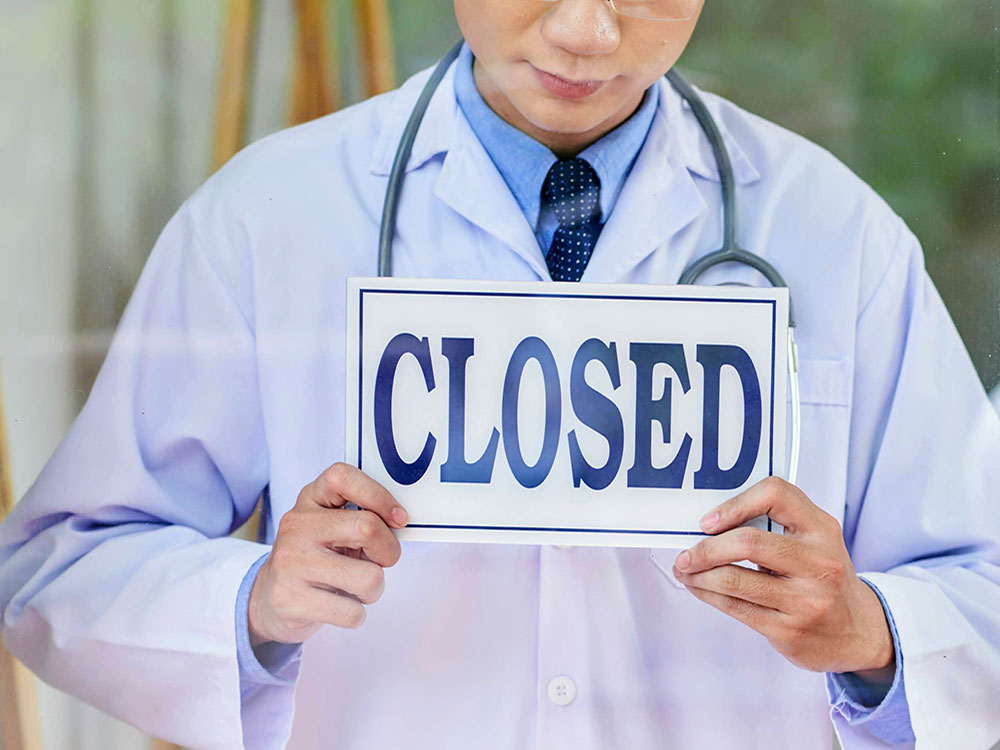 DoctorHoldingClosedSign.jpg
