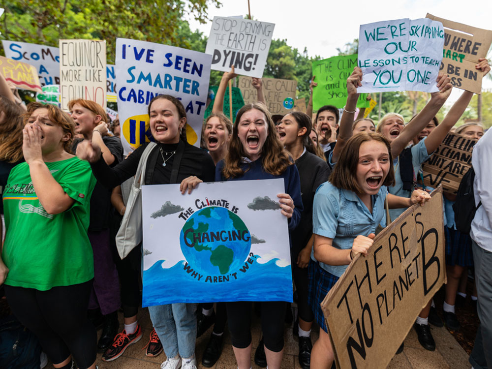 A large group of student protesters gathers with placards reading several different things, including 'There&rsquo;s No Planet B,' 'Stop Denying the Earth Is Dying' and 'The Climate Is Changing &mdash; Why Aren&rsquo;t We?'