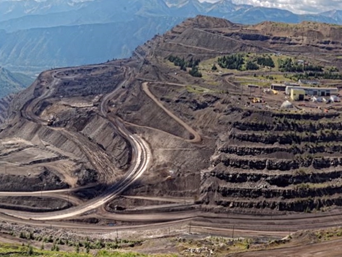 An aerial photo shows a series of carved terraces and roads on a mountain.