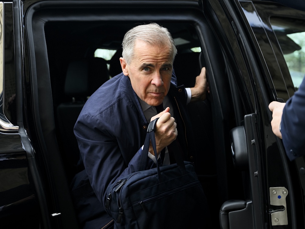 Mark Carney, a 61-year-old light-skinned man with short grey hair, steps out of a limousine.