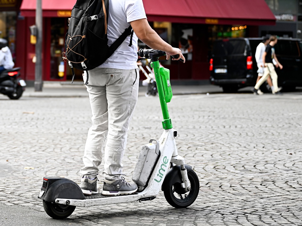 A person rides a Lime e-scooter.