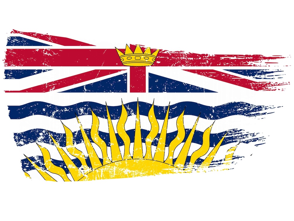 A graphic illustration treatment of the British Columbia flag shows the flag in rough, fading brush strokes. The flag features a union jack above an illustration of a yellow sun on a blue and white illustration suggesting ocean waves.