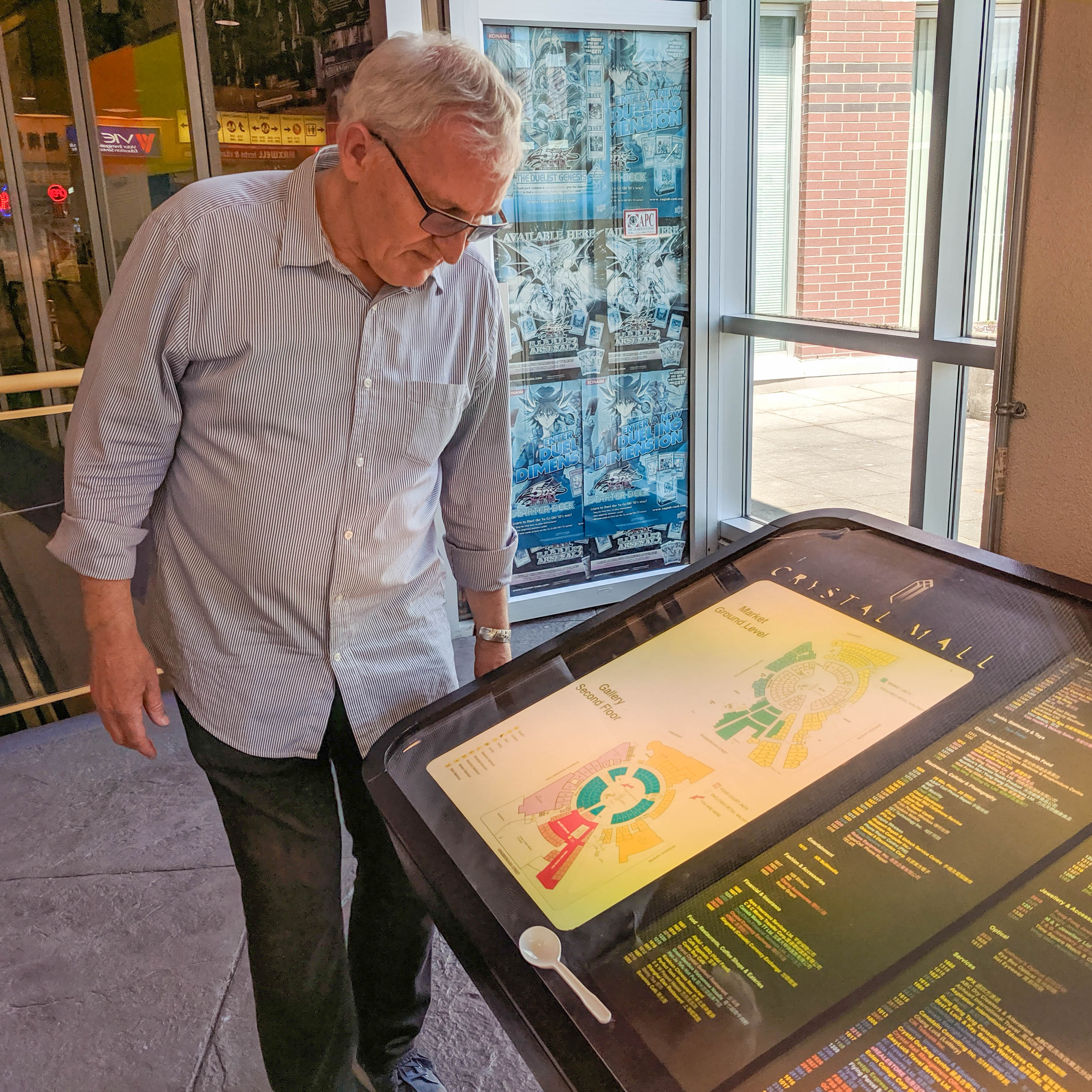 An older white man with white hair tilts his head down to consult the Crystal&rsquo;s parking map.