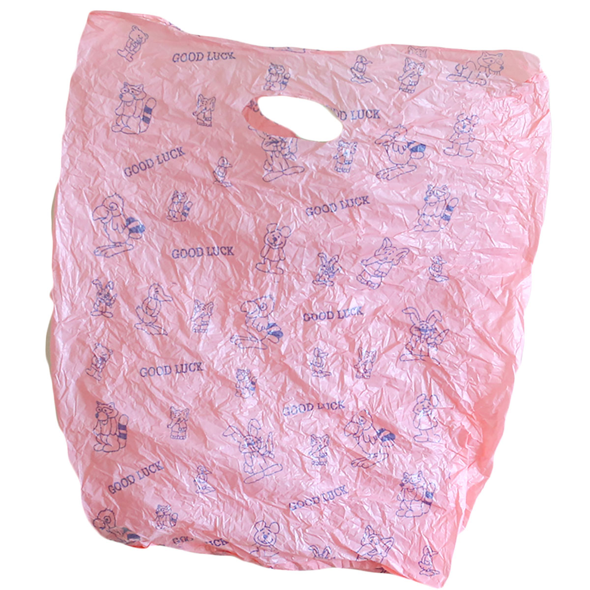 A light pink bag with cartoon animal clip art reads &ldquo;good luck&rdquo; in blue text.