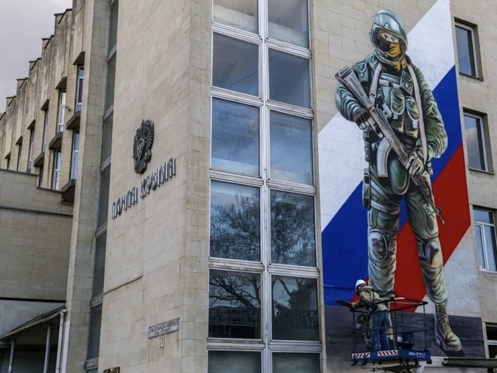 A mural of a Russian solider painted on the side of a building.