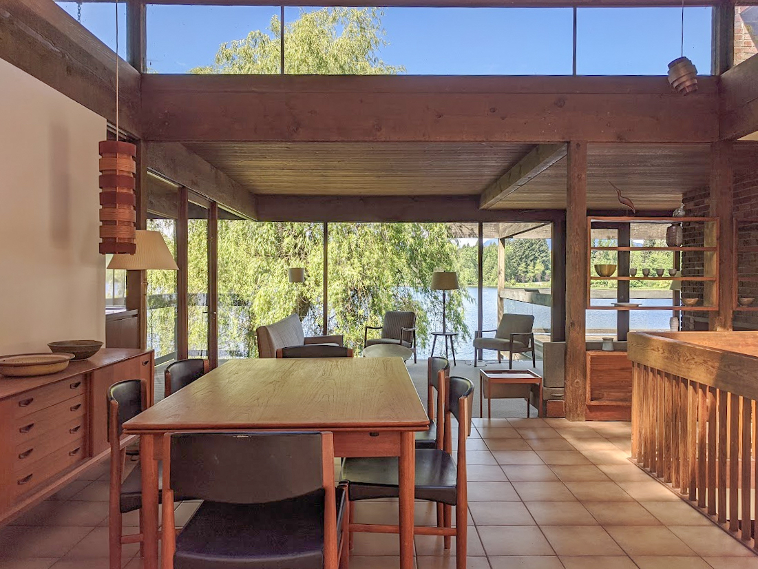 The dining and living room of a beautiful mid-century home on a sunny day.