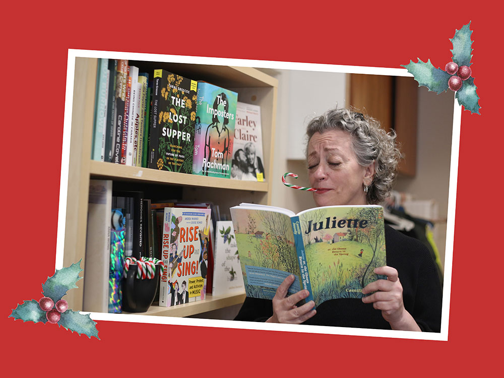 Dorothy Woodend, a woman with curly grey hair and a light skin tone, reads the graphic novel 'Juliette' with a candy cane in her mouth.