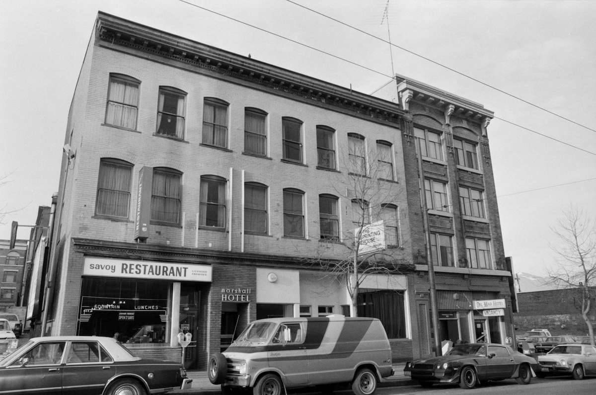 A black and white photo shows the Marshall Hotel, which is three times as wide as the skinny Del Mar but only three storeys, to the left of the Del Mar, which is skinny and four storeys.