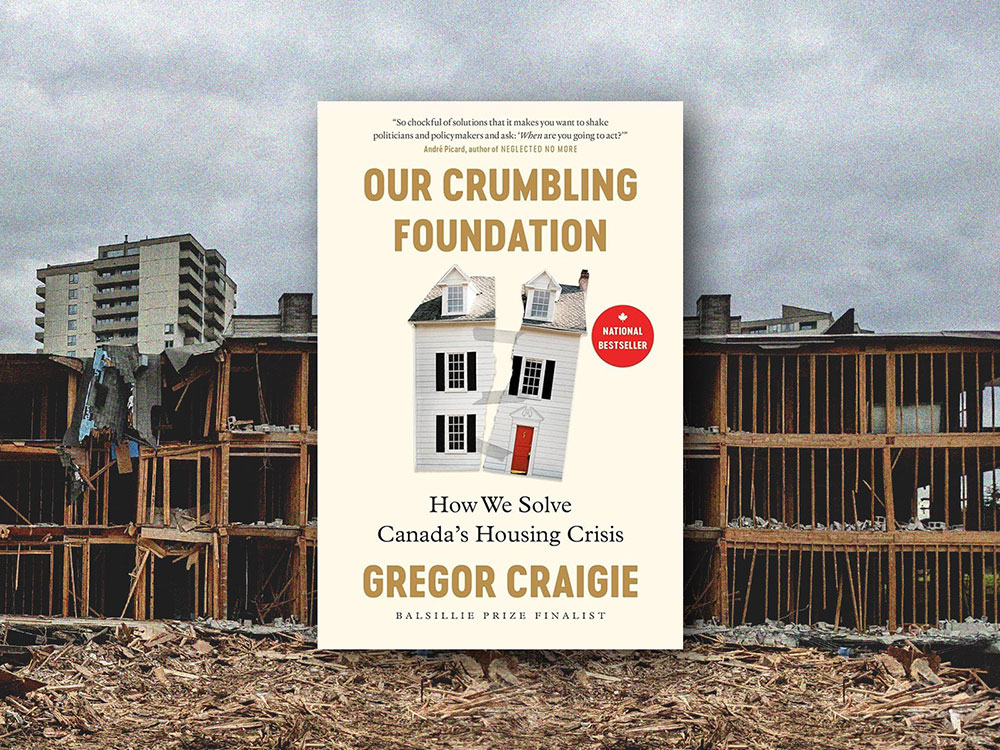 The book cover for 'Our Crumbling Foundation: How We Solve Canada’s Housing Crisis' by Gregor Craigie features a photo of a white home torn in half against a cream background. The book cover is laid over a photo of a three-storey wood frame apartment building under demolition against a grey sky.