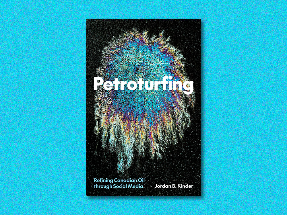 The cover of a book shows a rainbow bloom of oil on asphalt with the word 'Petroturfing' in white sans-serif text across the centre. It floats on a blue background.