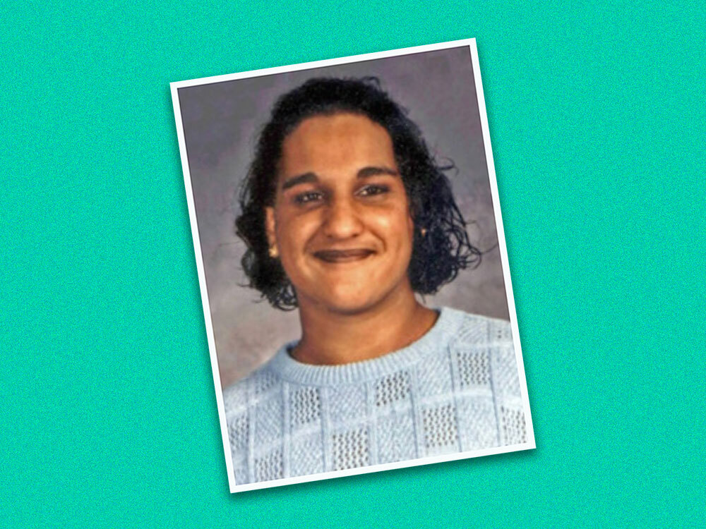A colour yearbook photo of a young teen with chin-length wavy dark hair, medium skin and a light blue sweater is positioned at an angle against a turquoise background.