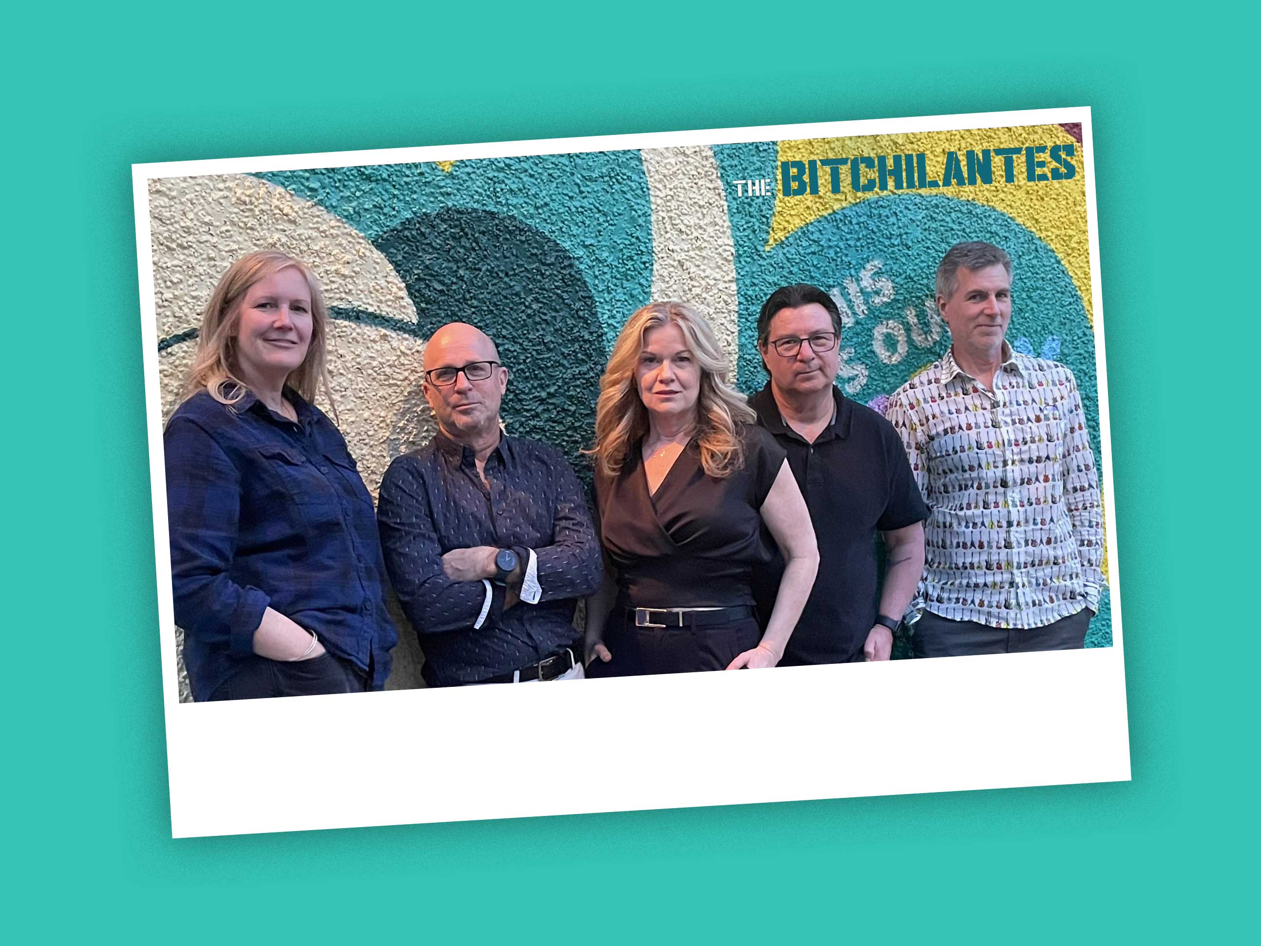 Five people stand against a textured wall featuring a mural in white, dark green, turquoise and yellow. They are middle-aged adults in casual streetwear. From left to right, Coleen MacEachern has blonde hair and a navy button-down shirt, Patrick Carroll has glasses and a dark button-down shirt, Linda Rae has wavy blonde hair and a brown top, Tyronne L'Hirondelle is wearing a dark button-down shirt and glasses and Shawn Conner has short grey hair and is wearing a grey and white patterned button-down.