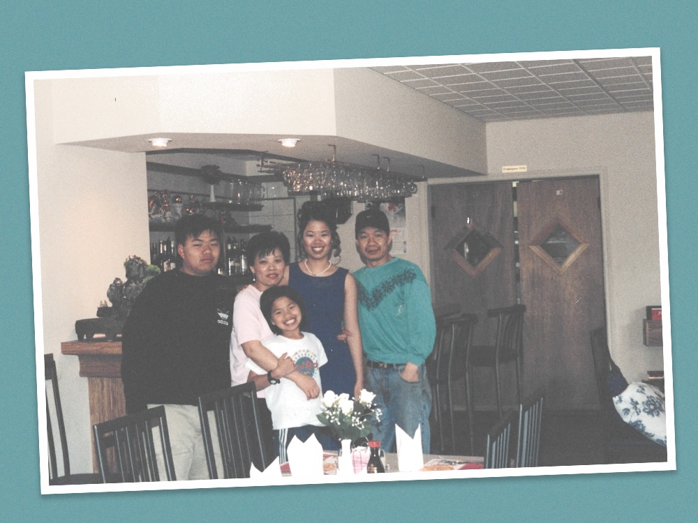 A photo shows Rachel Phan and her family — her older brother and sister and her mother and father — standing in their first restaurant, wearing ’90s fashions. Phan is a young child and her siblings are older.