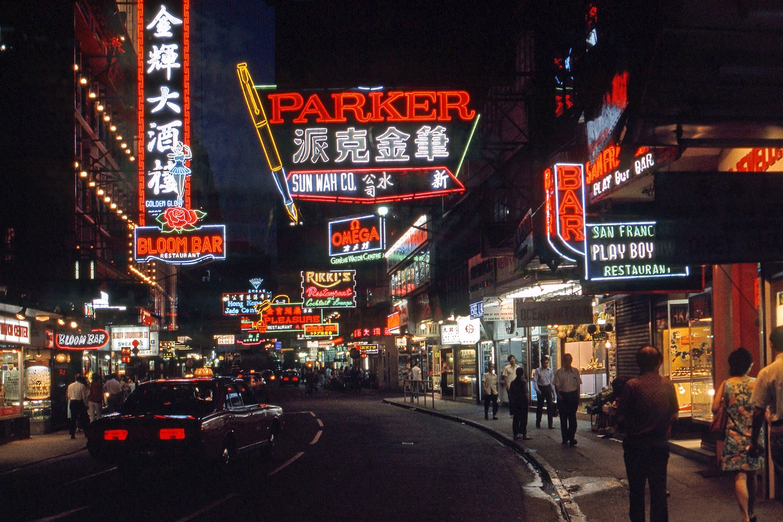 Colourful neon lights illuminate a nighttime streetscape in Hong Kong.