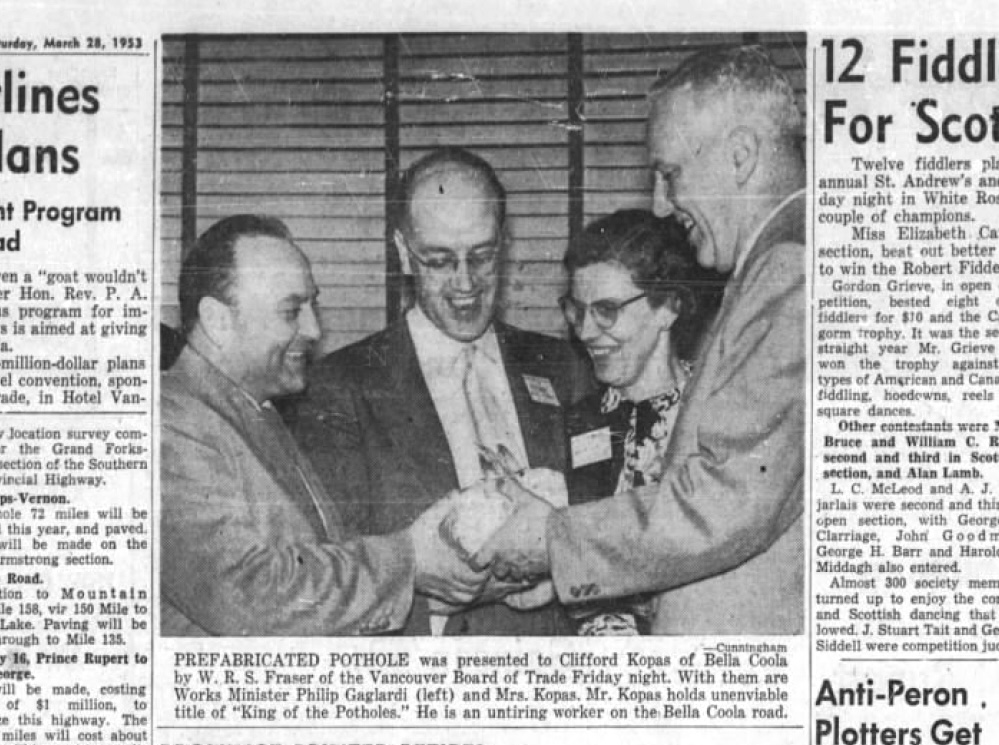 An old newspaper clipping shows two men presenting a man and a woman with a rock-like item in a black and white photo.