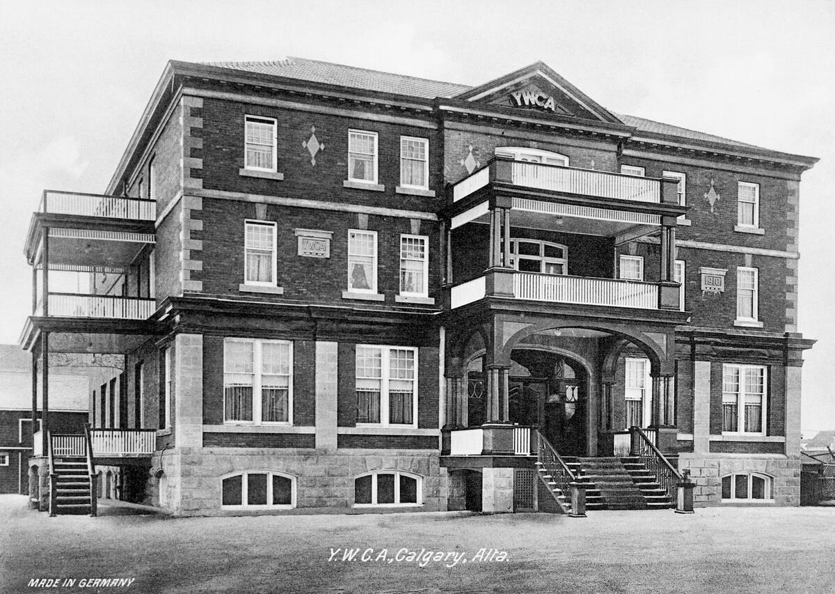 A black-and-white photograph of a large brick building features &ldquo;YMCA&rdquo; at its peak.