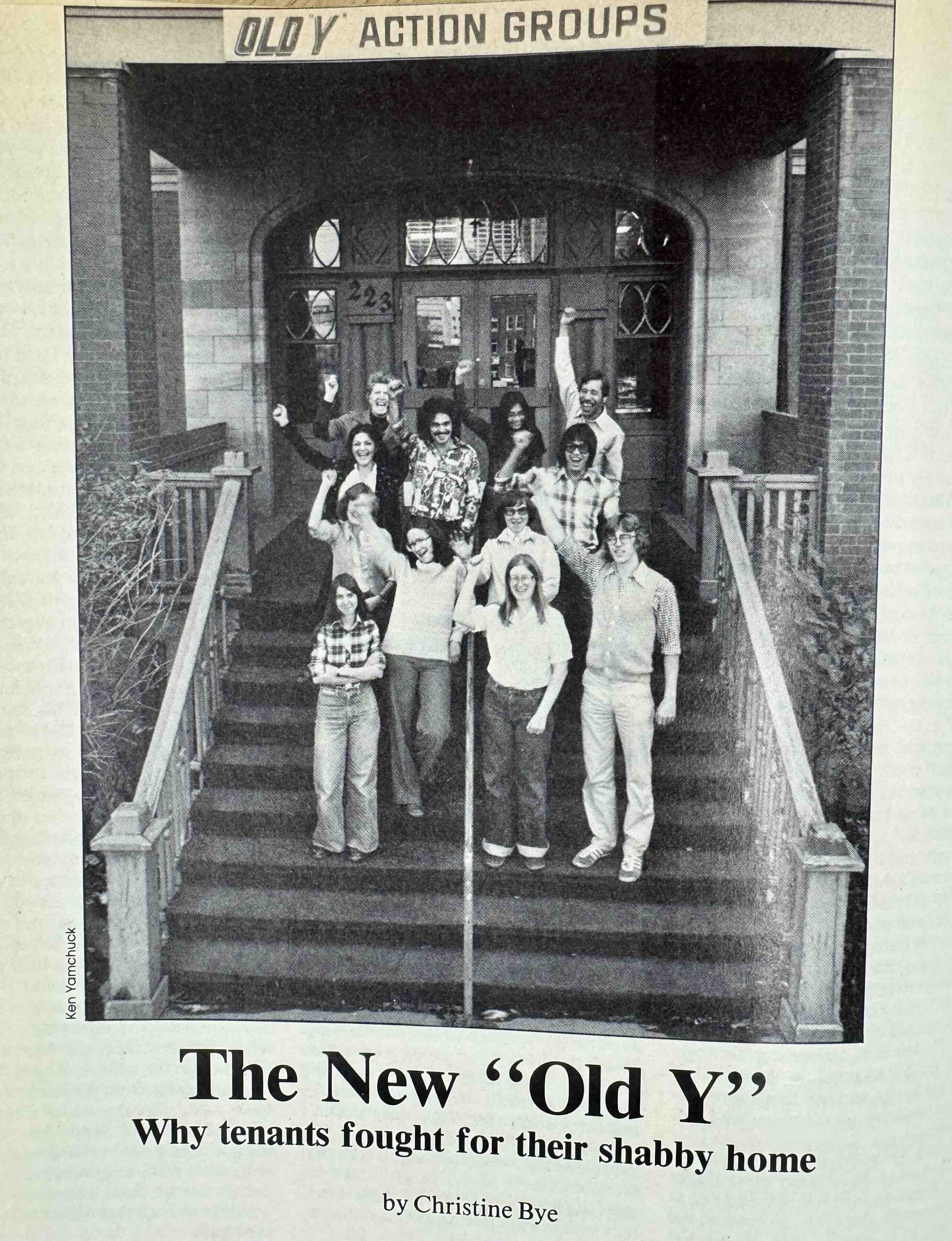 A black-and-white magazine clipping features a photograph of a group of people standing on a flight of stairs outside a historic building with their fists up in solidarity, smiling. They are standing below a sign that reads &ldquo;Old Y Action Groups.&rdquo; A headline at the bottom of the page reads &ldquo;The New &lsquo;Old Y:&rsquo; Why tenants fought for their shabby home.&rdquo;