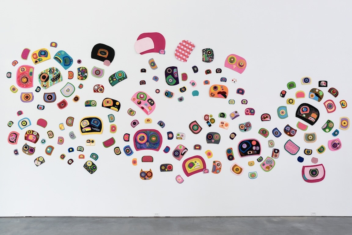 A colourful collection of &lsquo;hybrid ovoids&rsquo; are arranged against a white wall in bold, warm jewel tones.