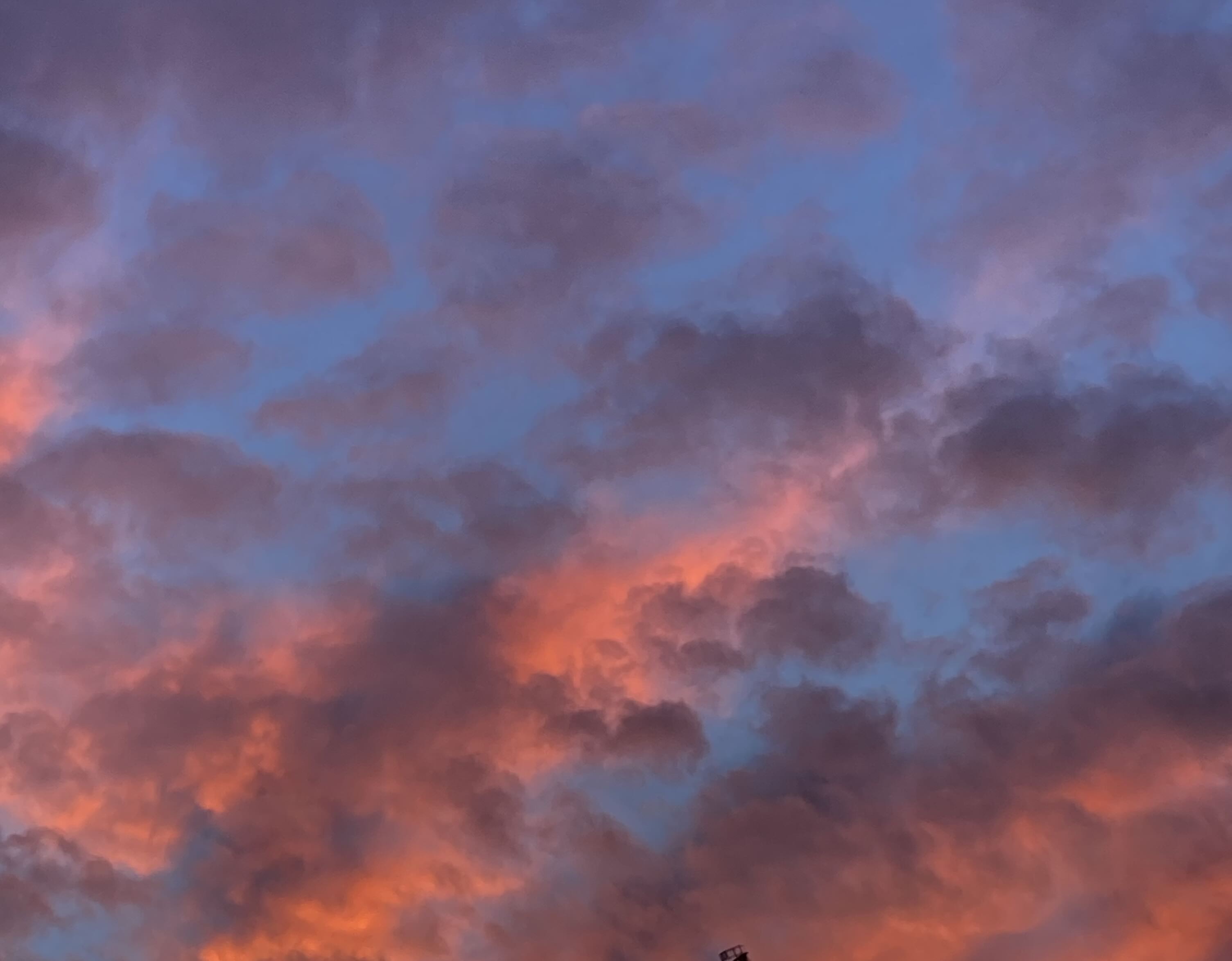 A sky featuring dark blue, grey and deep pink clouds.