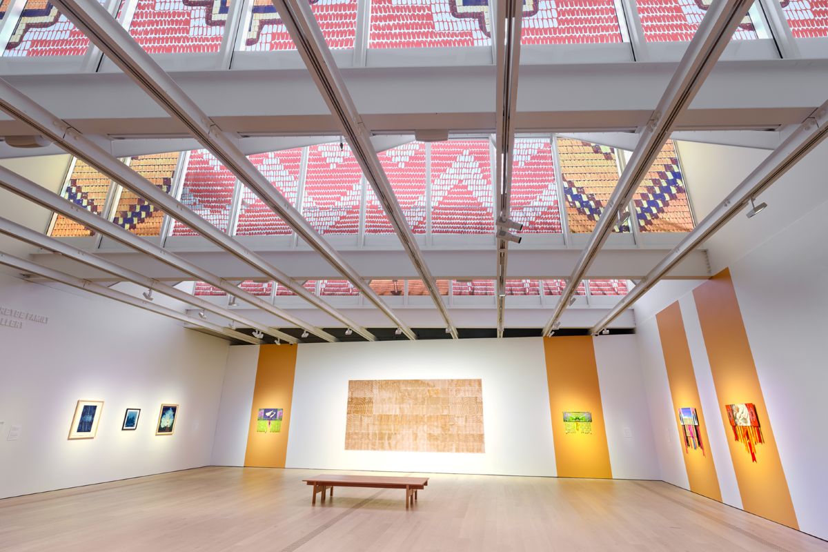 Top: A photo taken outside the Polygon gallery shows window coverings on the triangular, sail-like skylights of the gallery. Bottom: An interior view of the gallery shows Tania Willard&rsquo;s art on the walls, and the interior view of &lsquo;Safelight&rsquo; on the skylights of the gallery.
