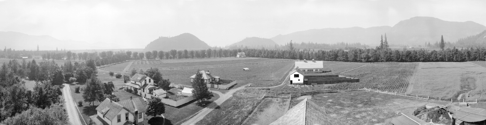 An elevated black and white panorama image shows fields and late 18th-century farm buildings.