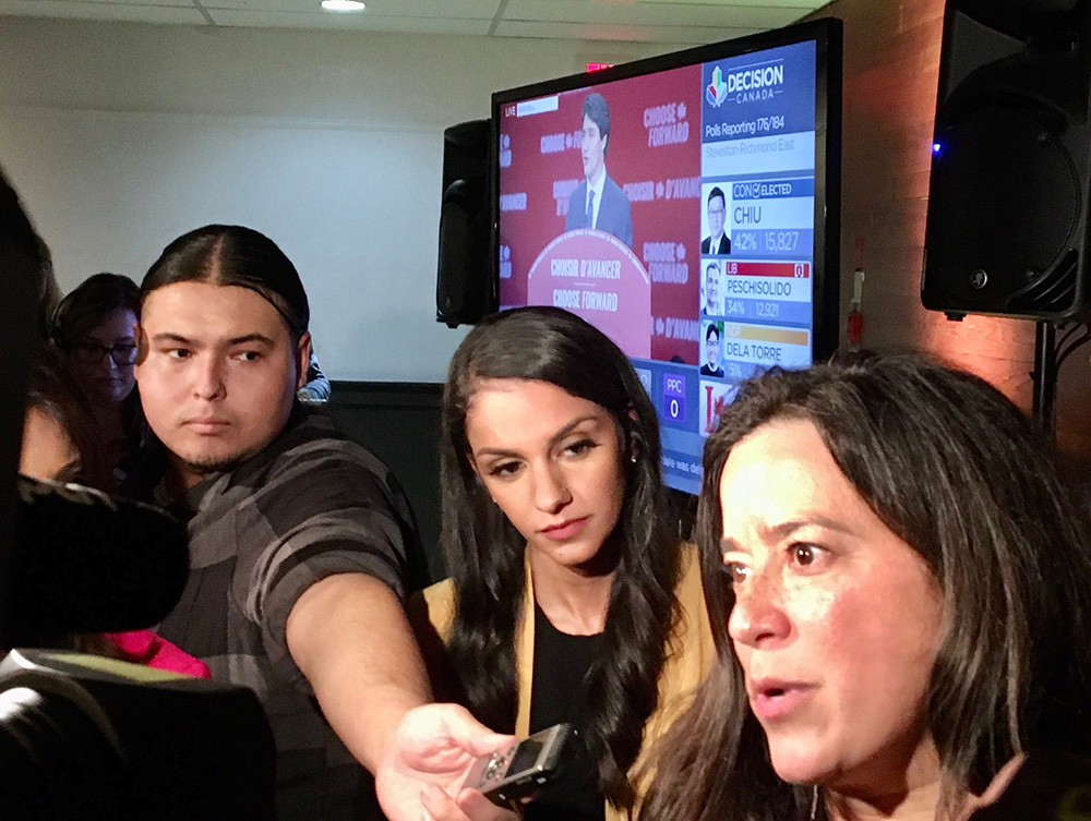 Reporter Jamin Mike holds a recording device in front of Jody Wilson-Raybould as she speaks.