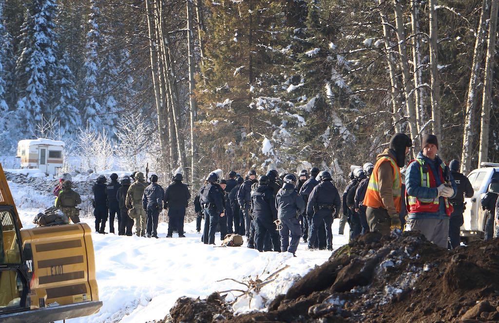 About 50 RCMP officers on the Morice West Forest Service Road in November 2021. It is snowy. They are preparing to arrest land defenders.