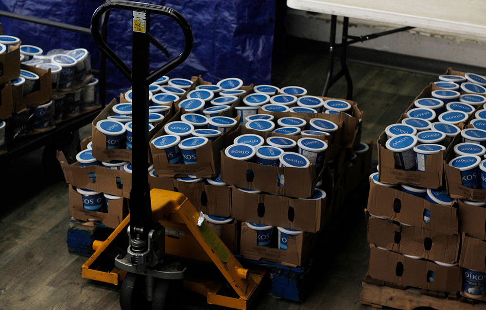 Flats of Oikos Greek yogurt sit on a pallet jack.