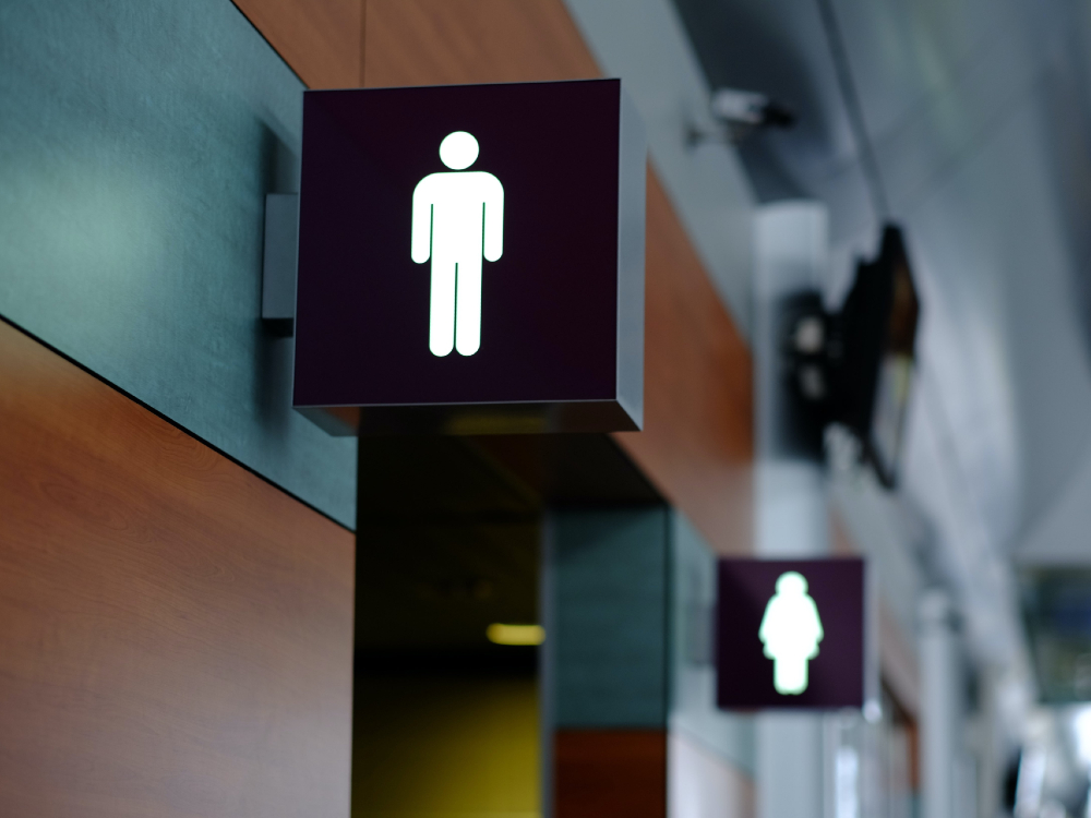 Washroom signs for the men&rsquo;s room and women&rsquo;s room are visible in a public location.
