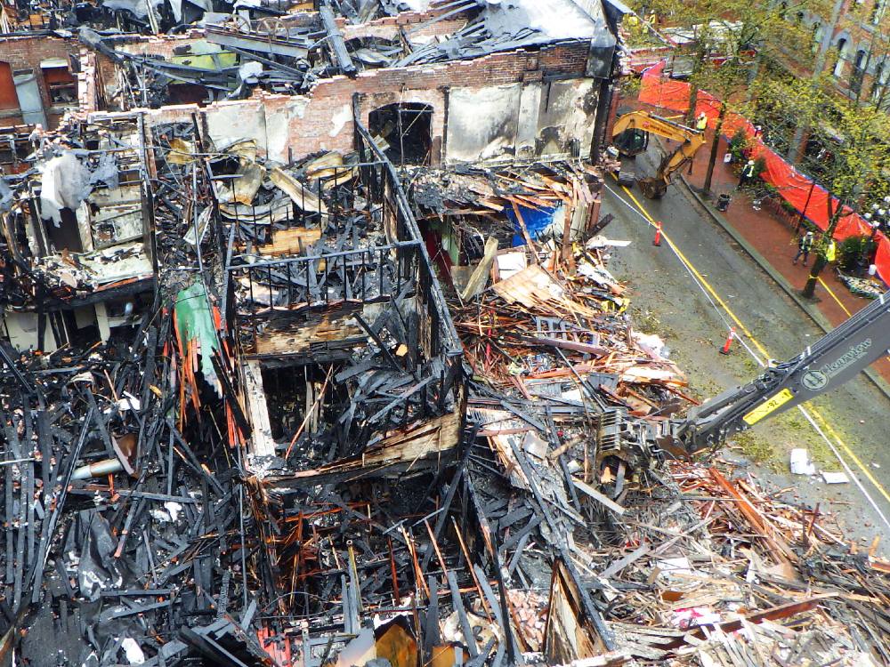 A view from above shows collapsed and blackened walls with no roof on the fourth floor of the Winters Hotel after a fire.