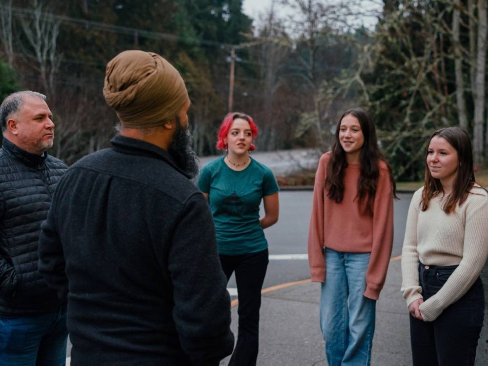 Jagmeet Singh and Gord Johns, stand outside with three youth from the Qualicum Beach chapter of Fridays for the Future. 
