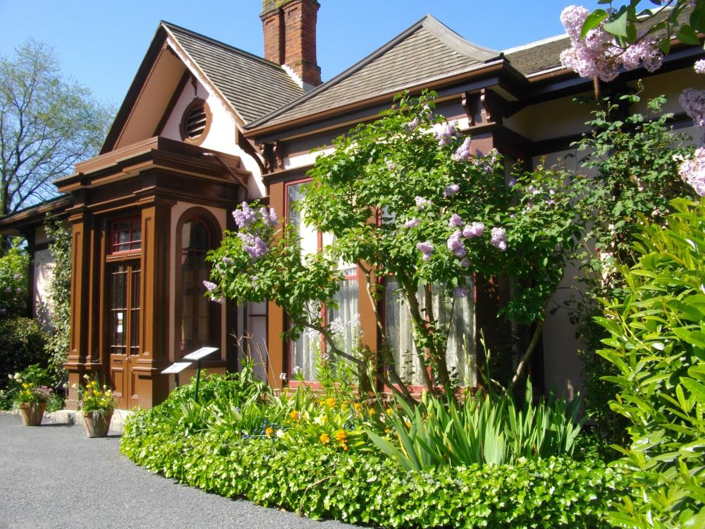 A pretty Victorian house with lush gardens.