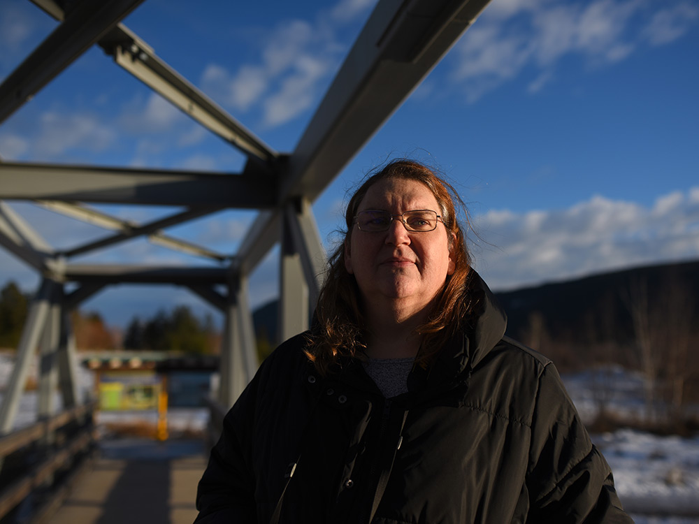 A woman in front of a bridge.