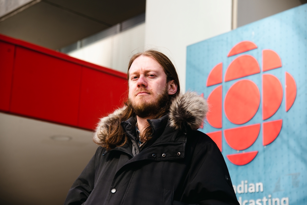 Julian Uzielli, producer for CBC Radio&rsquo;s Podcast Playlist and the director for new members and precarious workers for CBC&rsquo;s Toronto branch of the union from 2019 to 2020, stands outside the Wellington Street entrance of the CBC Toronto building.