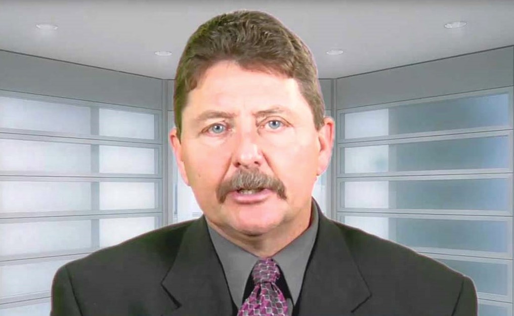 A photo of a middle-aged man with reddish hair, addressing the camera mid-sentence.