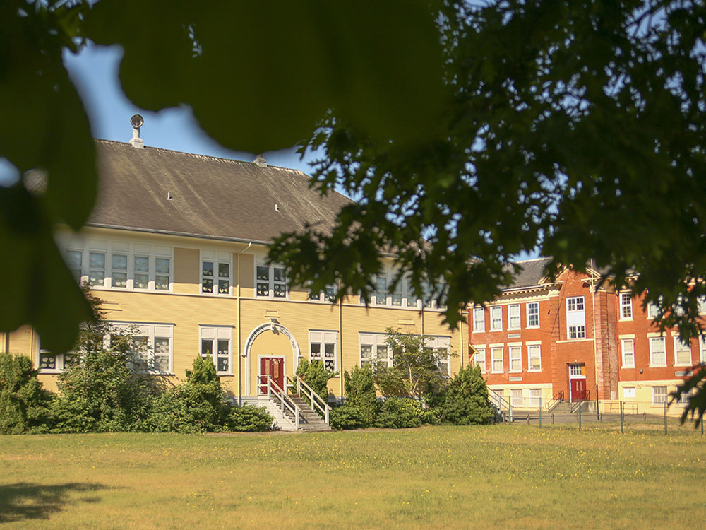 Two two-storey buildings make up the Sir Guy Carleton Elementary School campus. One has yellow siding, and one is red brick.