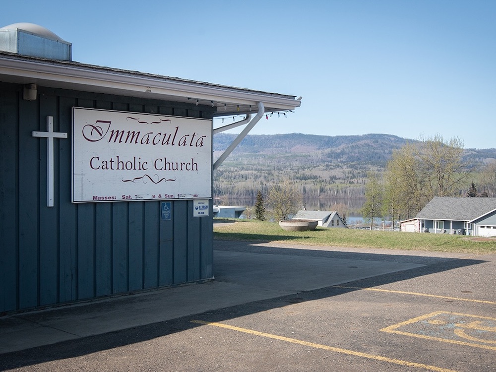 A one-storey blue building reads ‘Immaculata Catholic Church’ on the side.