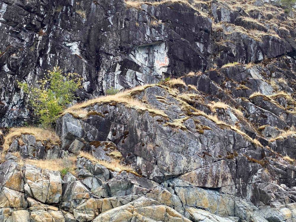 Red ochre pictograph on a large rock cliff face.