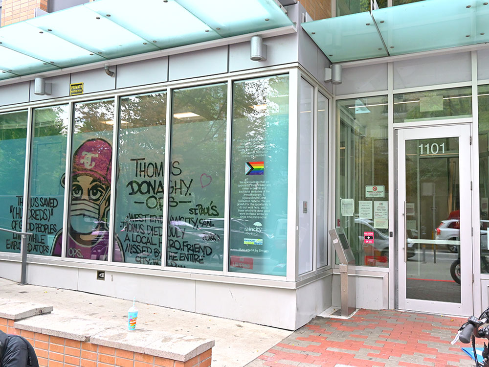 A photo of the Thomus Donaghy overdose prevention site in downtown Vancouver features a graffiti portrait of Thomus Donaghy.