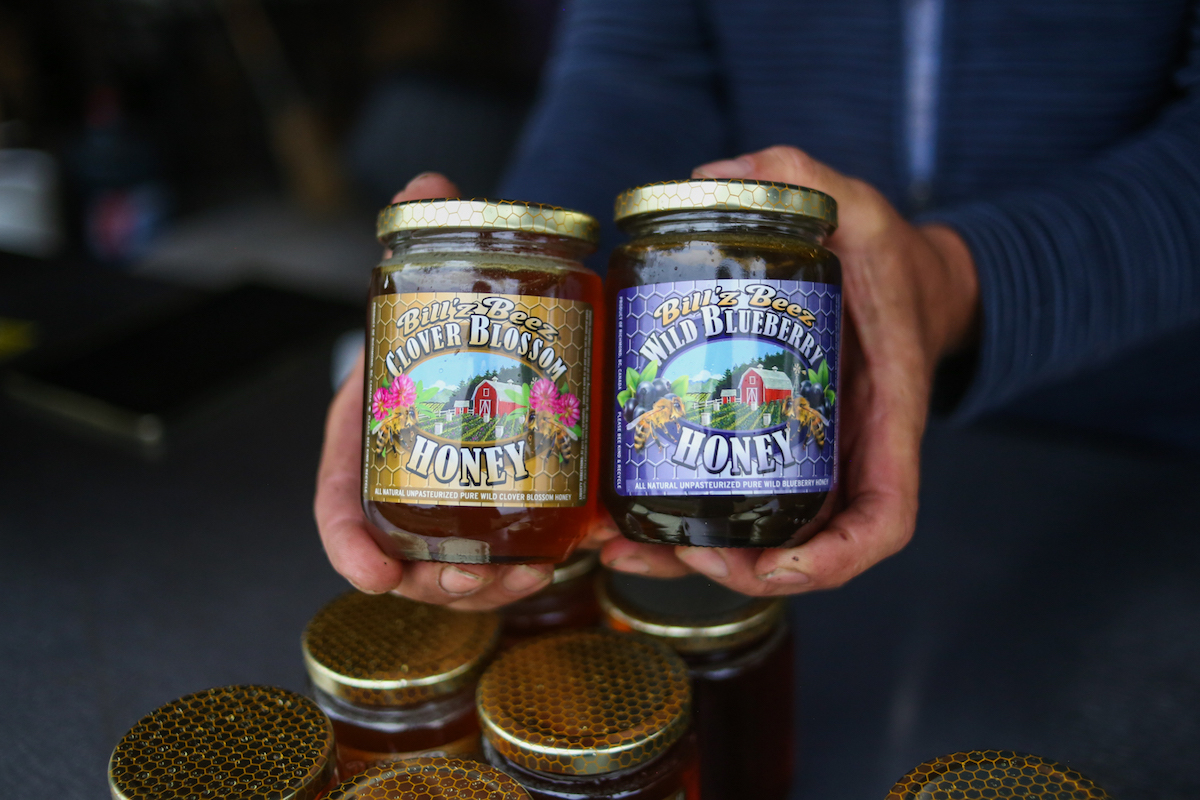 Hands holding up two jars of Billz&rsquo;z Beez brand honey.