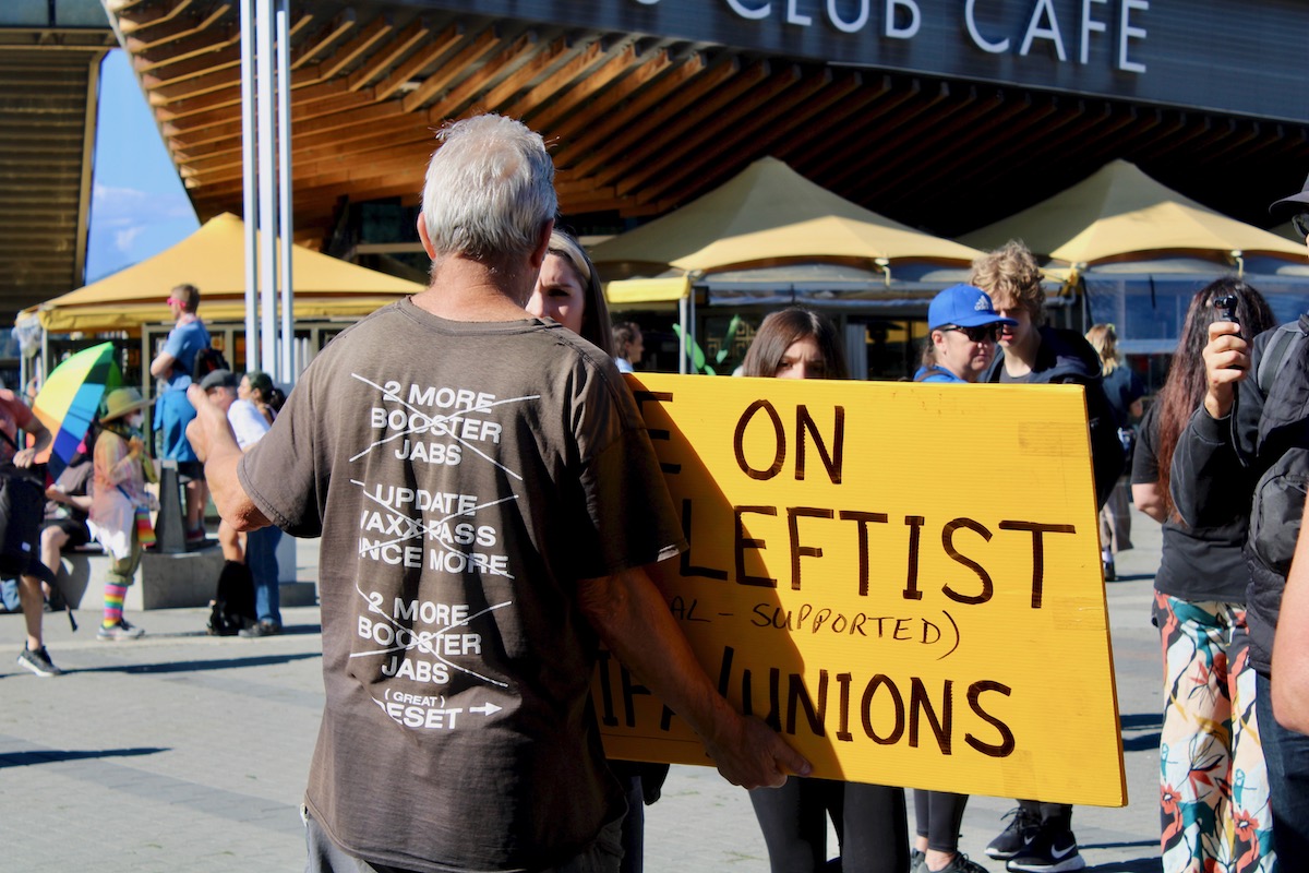 A man wears a shirt that references the “Great Reset” conspiracy theory.