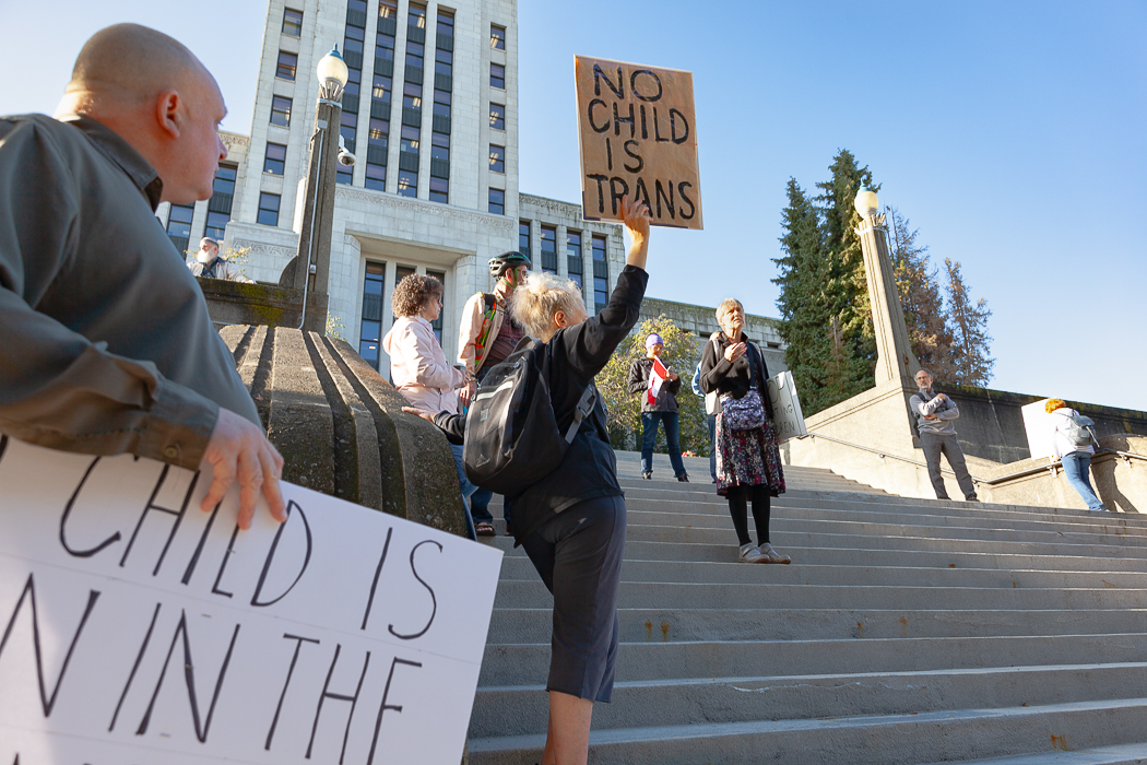 A small group of people gather on city hall stairs.