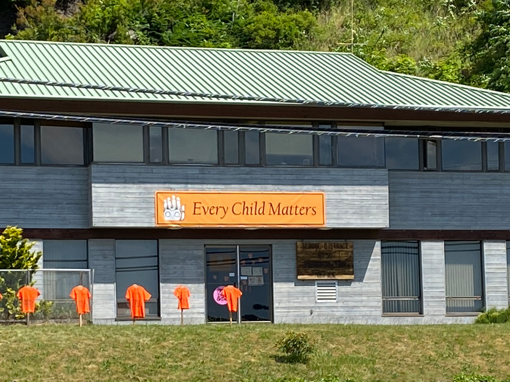 The SD50 office building in Haida Gwaii. There is an &lsquo;Every Child Matters&rsquo; banner on the building, and orange shirts set up in front of the building.