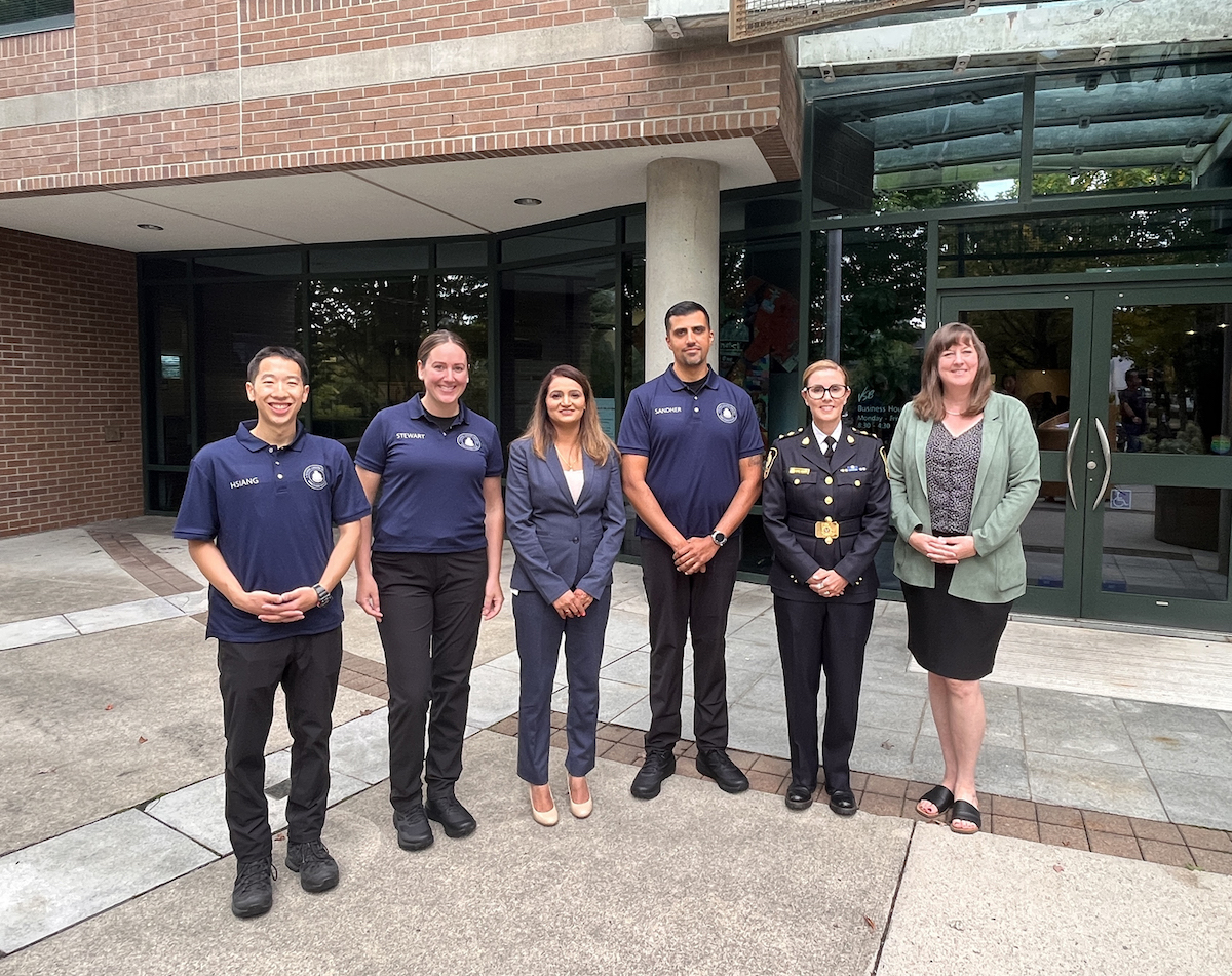 Six people pose for a photo, including three people wearing the updated SLO athletic gear.