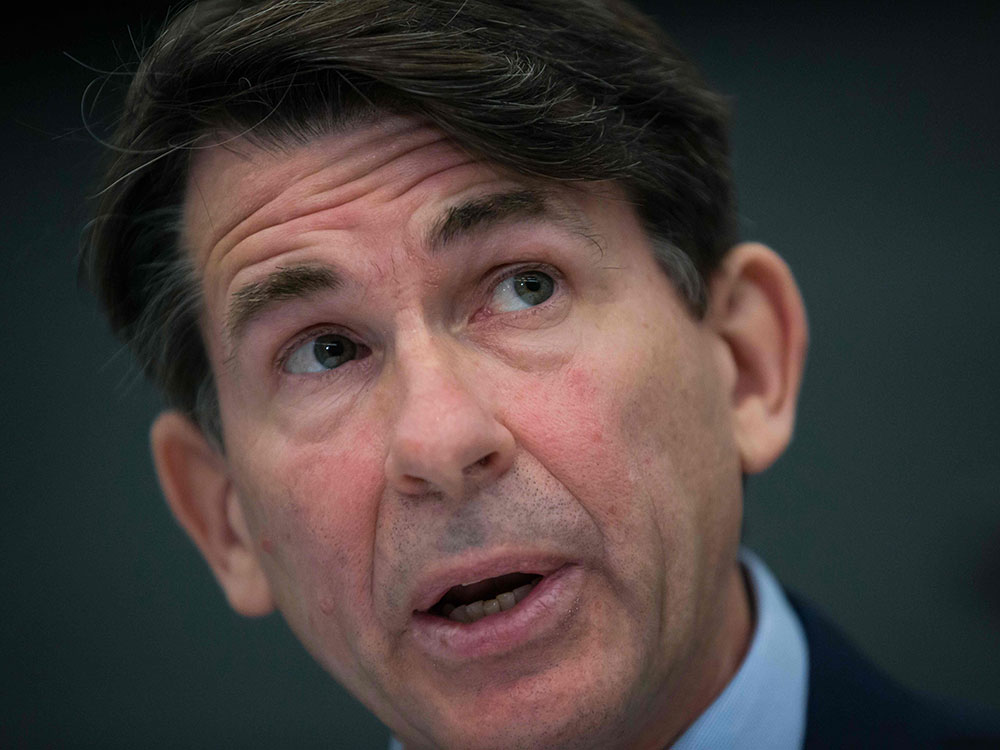Close up of a middle-aged man with light skin and dark hair.