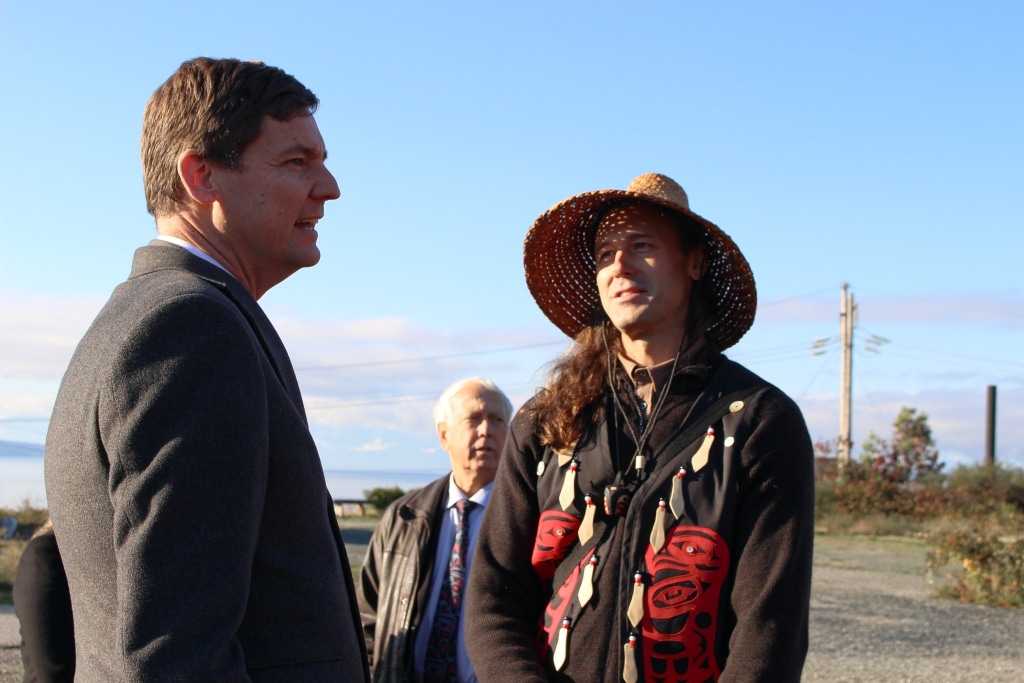 David Eby, left, and Dillon Johnson, right, stand on ground near tiskʷat.