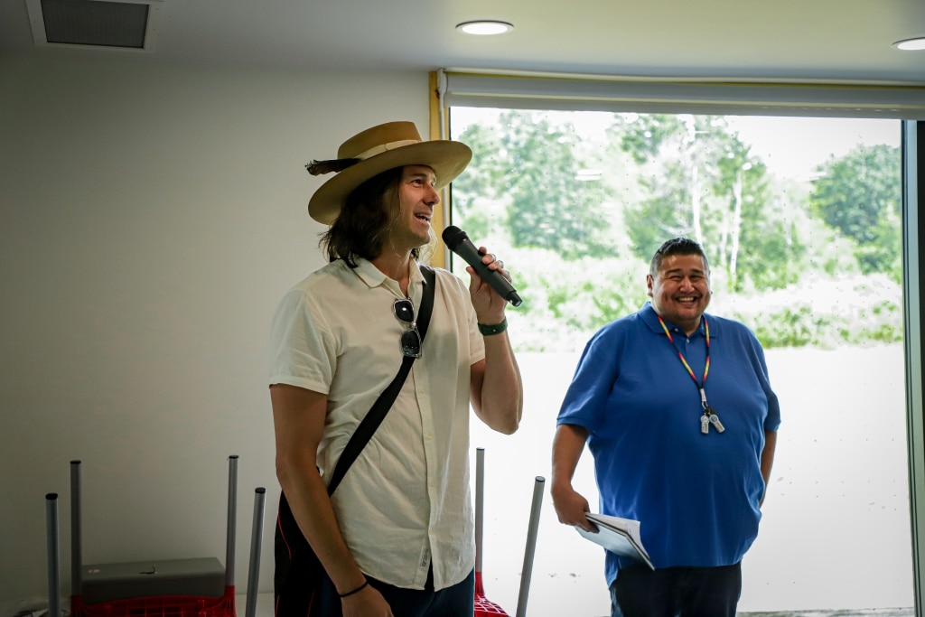 Two men address a crowd. They have been photographed in the middle of a joyous moment.