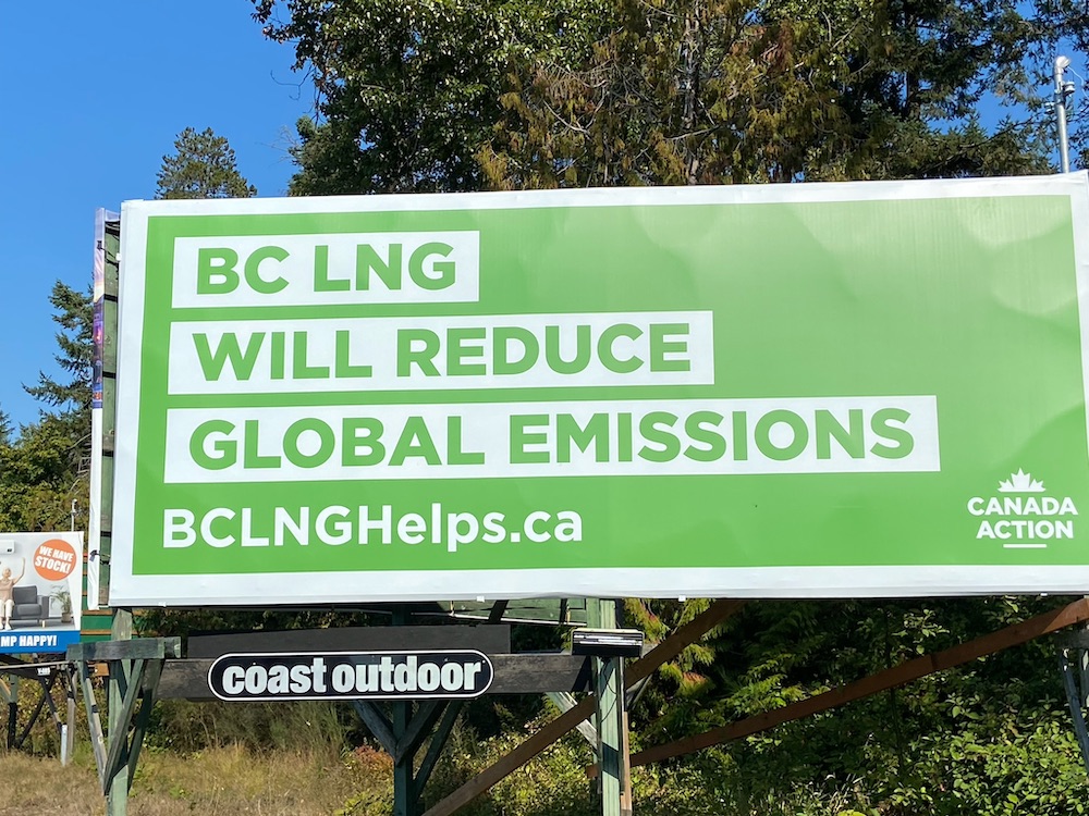 A billboard reads, 'BC LNG WILL REDUCE GLOBAL EMISSIONS.' The billboard is a nice friendly eco-green colour.