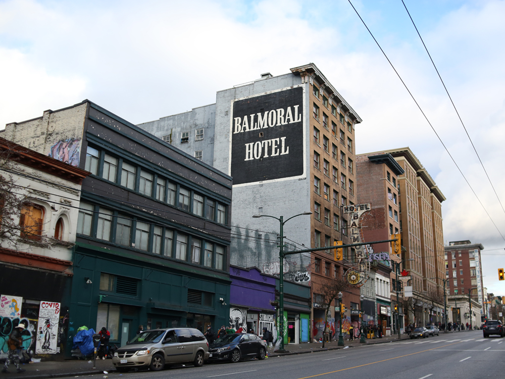 A photo shows buildings, including the Balmoral Hotel, alongside the north side of Hastings Street in Vancouver.