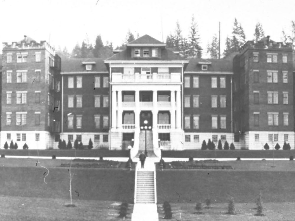 An old black and white photo shows a large brick building.